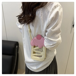 Detail einer rosa-beigen Crossbody-Tasche in Kuchenform mit Lochmuster und Polka-Dot-Futter