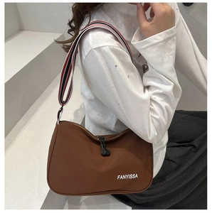 Close-up of a brown nylon crossbody bag with sporty striped strap and FANYISSA logo