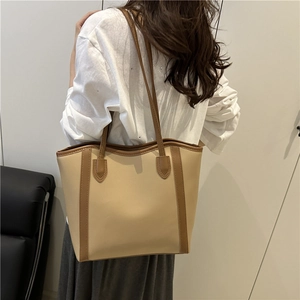 Elegant two-tone PU leather tote bag in apricot and brown shown on a model's shoulder