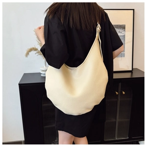 Détail du sac hobo crème minimaliste avec texture cuir grainé et grande capacité