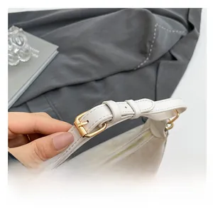 Detailed shot of the cream shoulder bag adjustable strap and premium gold metal hardware