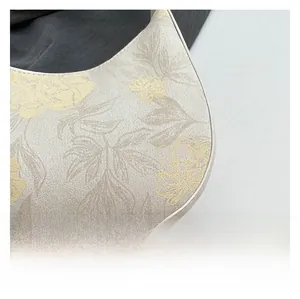 Detail of floral printed fabric on a Chinese style handbag with grainy texture focus