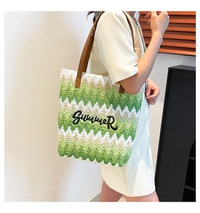 Macro detail of green and white woven beach tote with brown leather strap and Summer patch