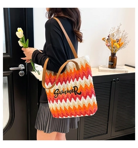 Close-up of rainbow striped straw tote bag with Summer embroidery and leather straps