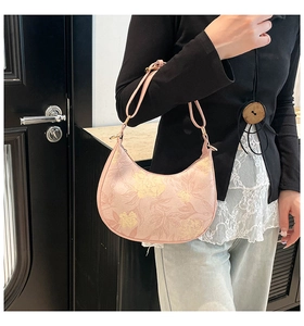 Pink floral hobo bag with adjustable leather strap shown worn as a crossbody purse