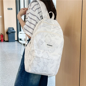 Vue détaillée du dos d'un sac à dos blanc avec motifs d'ours porté par un modèle