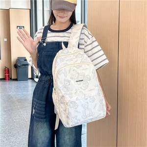 Vue détaillée d'un sac à dos blanc avec motif d'ours gris et poche frontale zippée