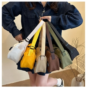 Collection of colorful canvas crossbody bags with adjustable straps and brand label