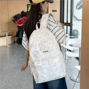 Photo de style d'un sac à dos blanc avec des oursons gris portés par un mannequin