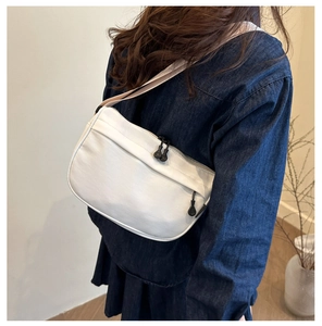 Side view of white nylon crossbody bag showing the curved shape and zipper details