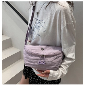 Detail of lilac crossbody bag featuring textured fabric and double triangle zip pullers