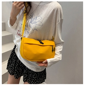 Detail view of adjustable strap and zipper closure on a vibrant yellow crossbody bag