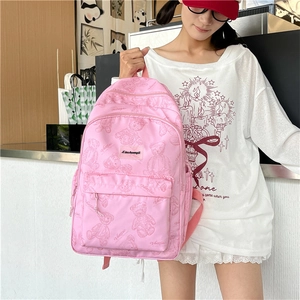 Détail d'un sac à dos rose à motifs ours avec poche zippée porté par un mannequin