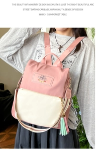 Detail of pink and cream contrast backpack with rabbit label and tassel charm