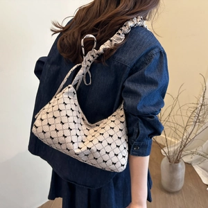 Chic beige canvas shoulder bag with black bow patterns and a scrunchie strap design