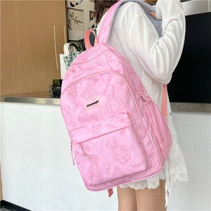 Gros plan du sac à dos rose avec motifs d'ours en peluche et étiquette tissée