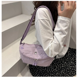 Detail of light purple nylon crescent bag with adjustable strap and metal logo