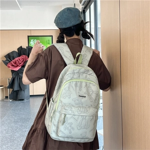 Détail du sac à dos beige avec motifs ours en peluche et fermetures éclair vert clair