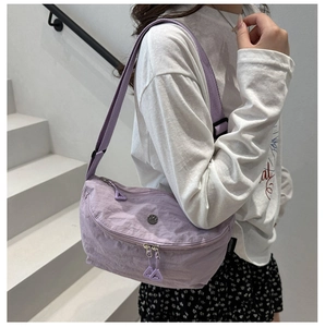 Detail view of light purple nylon dumpling bag with dual zippers and adjustable strap