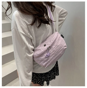 Back view of light purple crossbody bag with dual zippers and woven shoulder strap