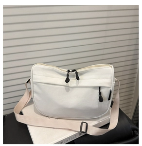 Detail of white nylon crossbody bag with zipper pocket and adjustable strap