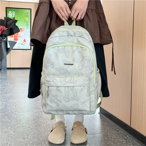 Détail du sac à dos vert clair avec imprimé ours et multiples poches de rangement