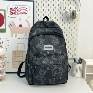 Détail d'un sac à dos en nylon noir avec oursons blancs et double fermeture éclair