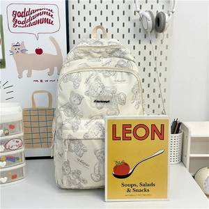 Détail du sac à dos crème avec imprimés d'ours en peluche dans un décor de bureau