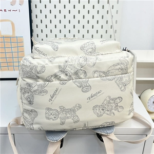 Détail du sac à dos en toile crème avec motifs d'ours gris et bretelles en maille