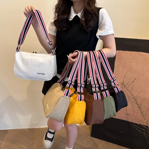Minimalist canvas shoulder bag with signature striped strap and logo detail