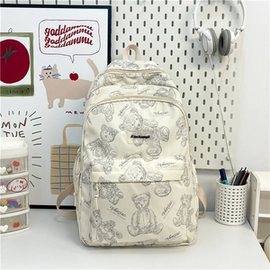 Détail d'un sac à dos crème avec motifs d'ours mignons et multiples compartiments