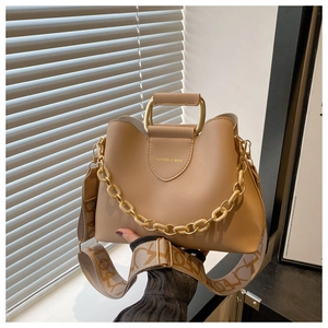 Detail of khaki leather handbag with gold U-shaped handle and broad lettered strap
