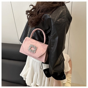 Détail du sac à bandoulière en daim rose avec une boucle carrée en strass scintillants