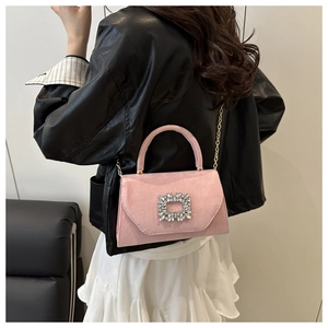 Dettaglio borsa scamosciata rosa con fibbia di cristallo e tracolla a catena dorata