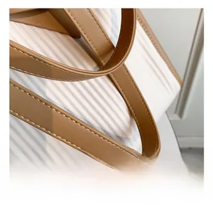 Detail showing white pleated texture material and brown leather handle with stitching