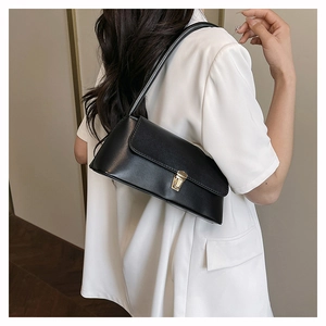 Détail d'un sac baguette noir mat minimaliste avec boucle en métal doré élégante