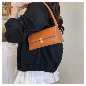 Gros plan d'un sac baguette en cuir marron avec boucle dorée et finition lisse élégante