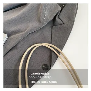 Detail of comfortable beige leather shoulder strap on a grey textured fabric tote bag