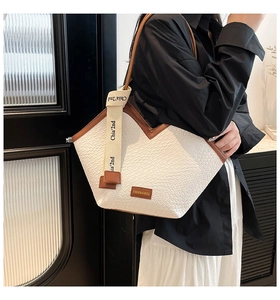 Detailed view of the woven white tote bag with V-cut opening and branded canvas ribbon detail