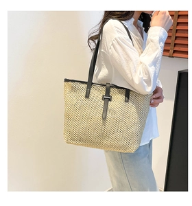Gros plan du sac cabas en paille beige avec lanières et boucle en cuir noir