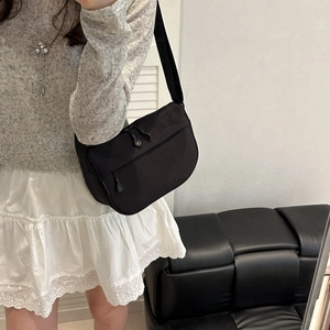 Minimalist black nylon crescent crossbody bag with adjustable wide shoulder strap for women