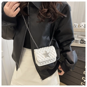 Close-up of white quilted mini crossbody bag with rhinestone star and silver chain