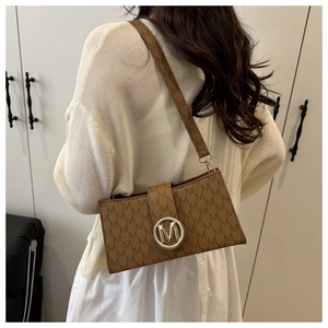 Detalle del bolso de hombro con monograma marrón y hebilla de metal dorado elegante
