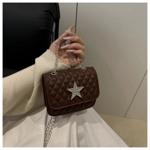 Dettaglio della borsa trapuntata in similpelle marrone con emblema a stella lucente