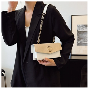 Detalle del bolso cuadrado pequeño con solapa beige texturizada y cierre de logo M