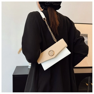 Detalle de bolso bandolera de cuero tejido con hebilla dorada logo M llevado por una modelo