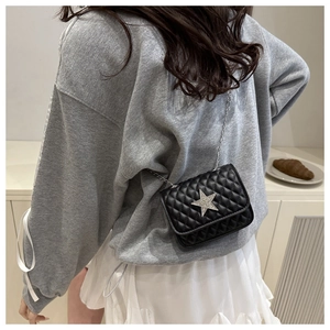 Dettaglio mini borsa trapuntata nera con stella d'argento e tracolla a catena