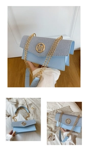 Dettaglio della piccola borsa a tracolla quadrata in pelle blu con fibbia dorata a M