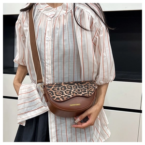 Detailed view of leopard print crossbody bag with wavy flap and adjustable fabric strap