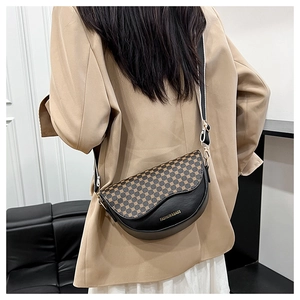 Detailed macro view of the black leather saddle bag with leopard print flap and strap